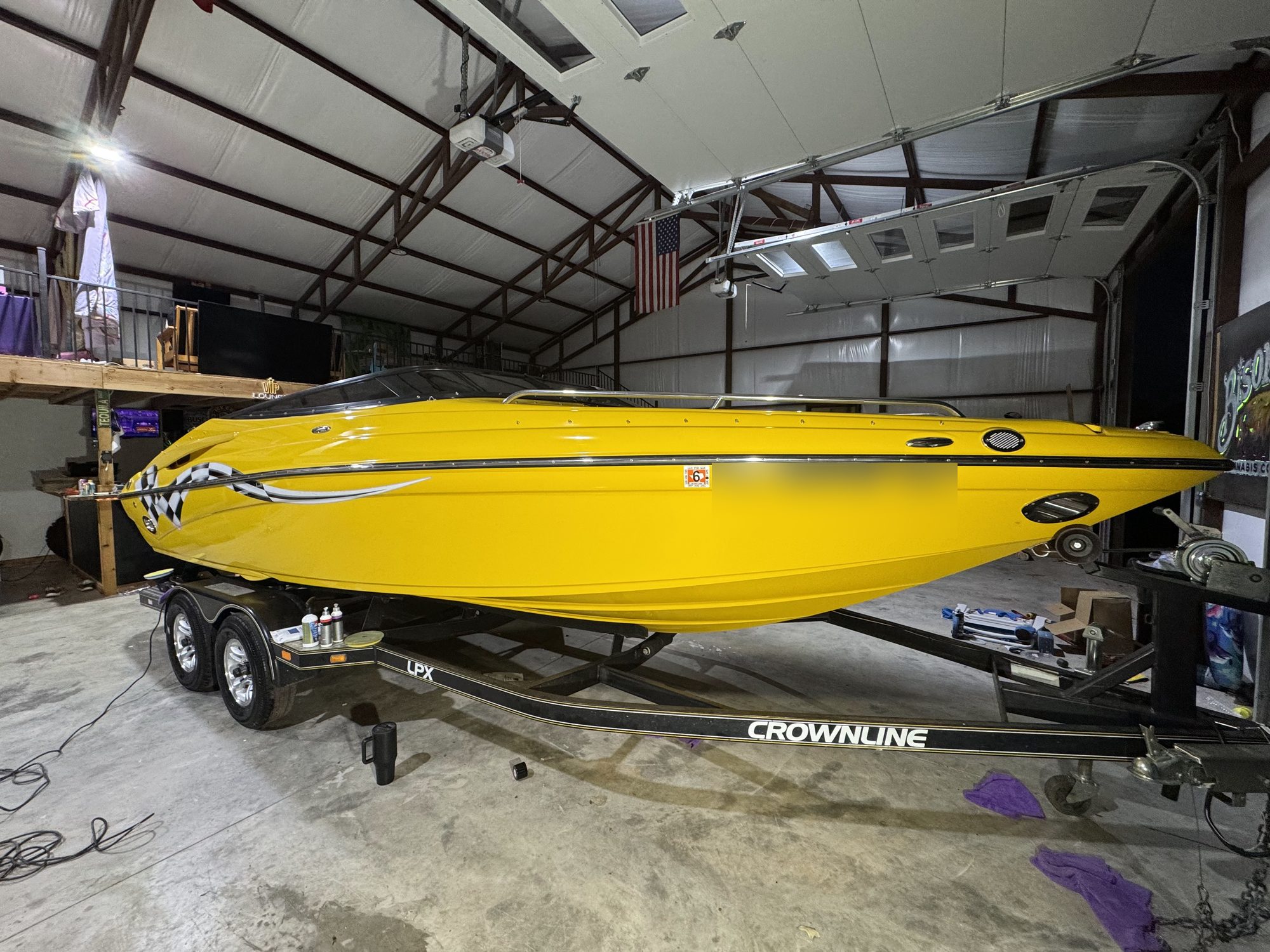 Yellow Crownline LPX boat on its trailer in the shop after a full polish